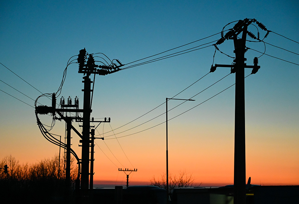 Electric poles with power lines at sunset. Electricity transmission.